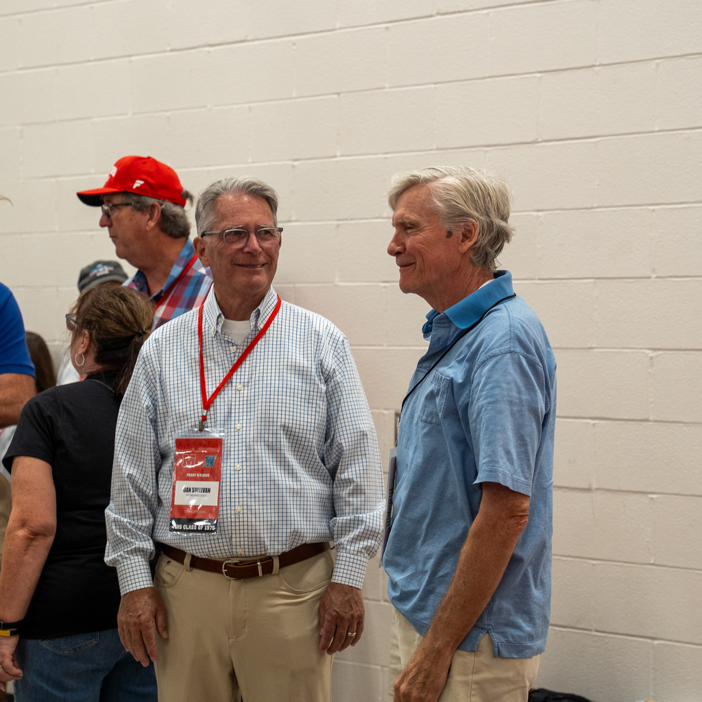 Two senior men smiling at one another 