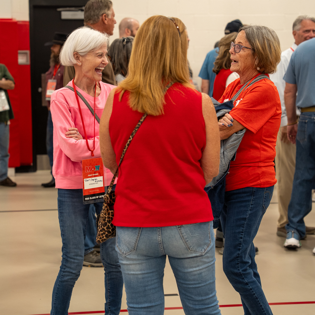 Three woman standing in a group laughing 
