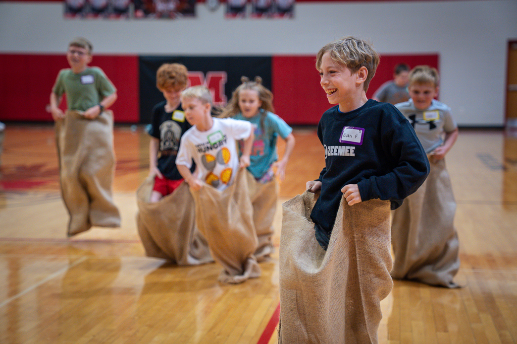 A student in a potato sack smiling