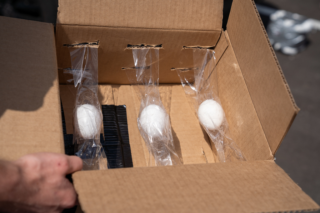 Three eggs taped to the side of a box 