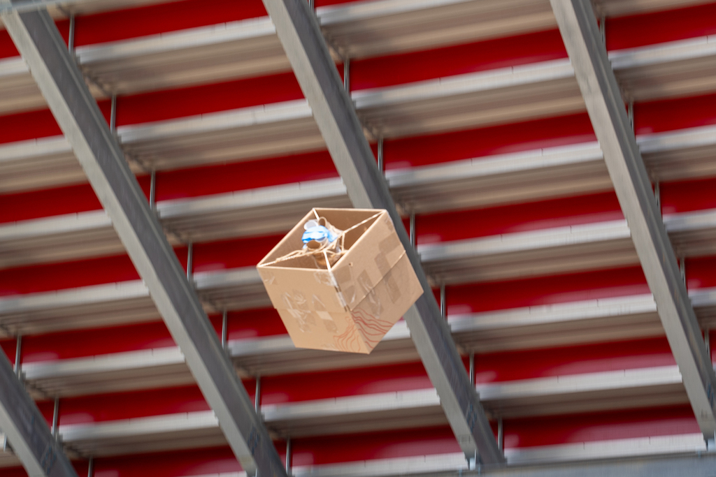 A cardboard box flying through the air with string inside