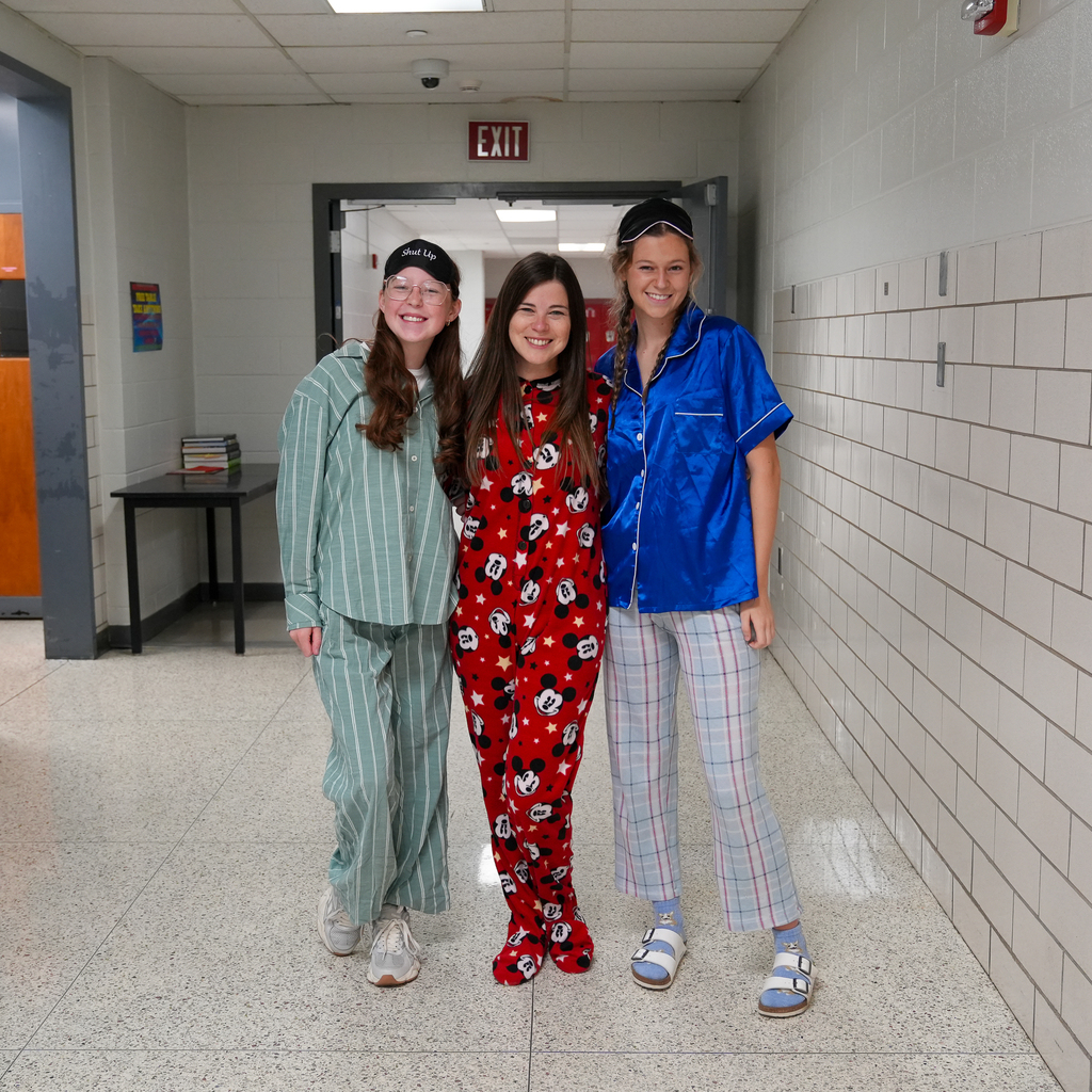 (Left to Right) a girl in green stripped pj set, woman with brown hair in a minie onsie, girl with braids in a blue PJ set