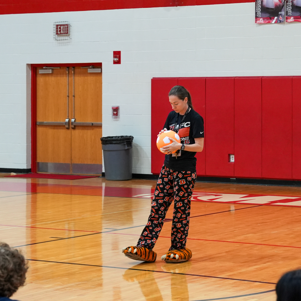 Woman holding a soccer ball with bengals pj pants and tiger slippers on