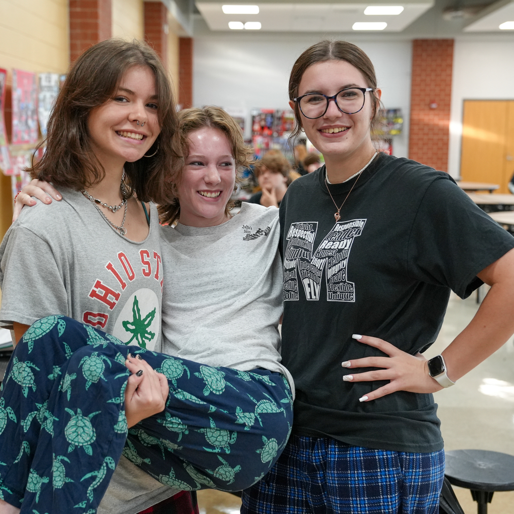 (Left to Right) Girl with nose ring and ohio state shirt holding a girl with turtle pj's bottoms, next to a girl with glasses 