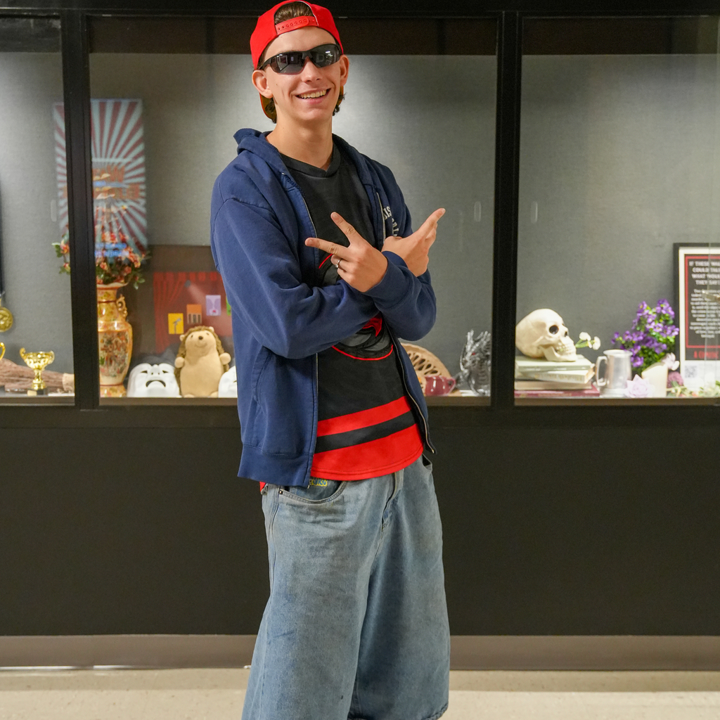 boy wearing shades giving peace sign with hockey jersey and jorts