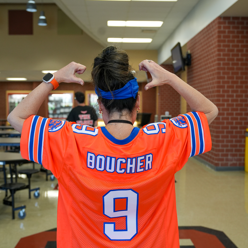 Woman pointing at name "Boucher" on back of jersey