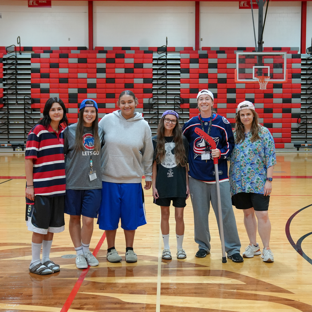 (Left to Right) Girl in oversized polo. woman with a cubs t-shirt and backwards hat, girl with gym shorts and grey sweatshirt, girl with oversized t shirt and backwards hat, woman with oversized hockey jersey and woman with hawaiian shirt and backwards hat