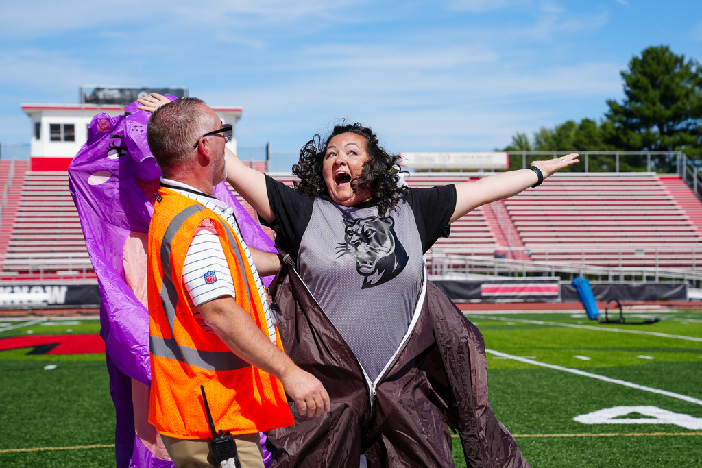 A woman with black curly hair coming out of a costume