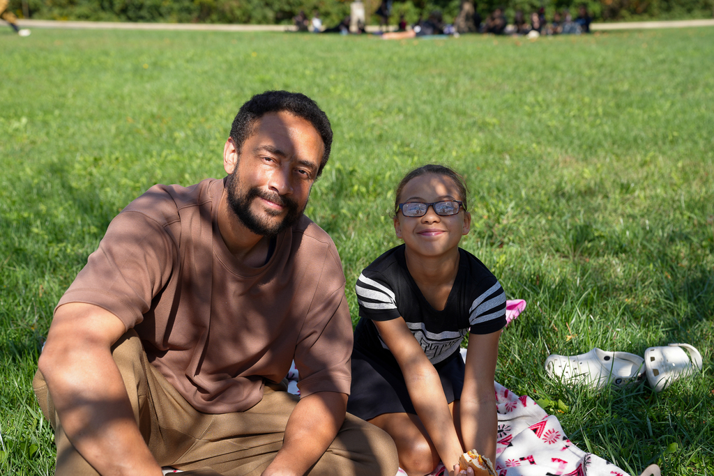 a man in a brown shirt with his daughter in glasses