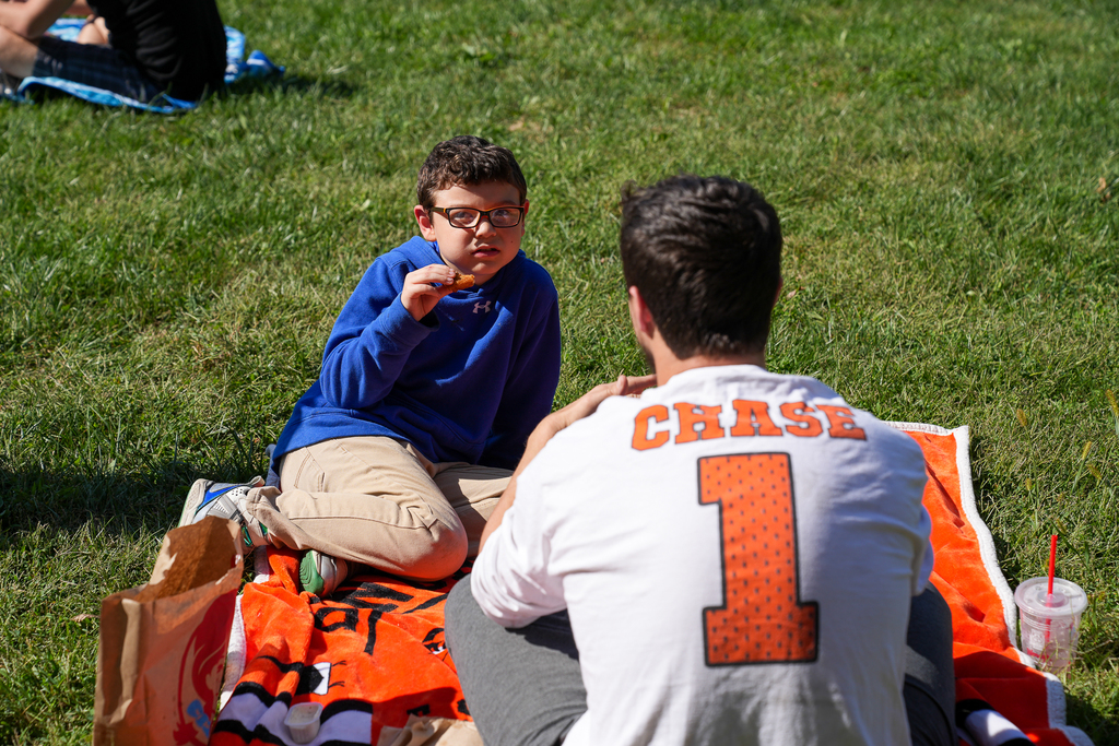 a man with a chase jersey talking to a boy in a blue sweatshirt