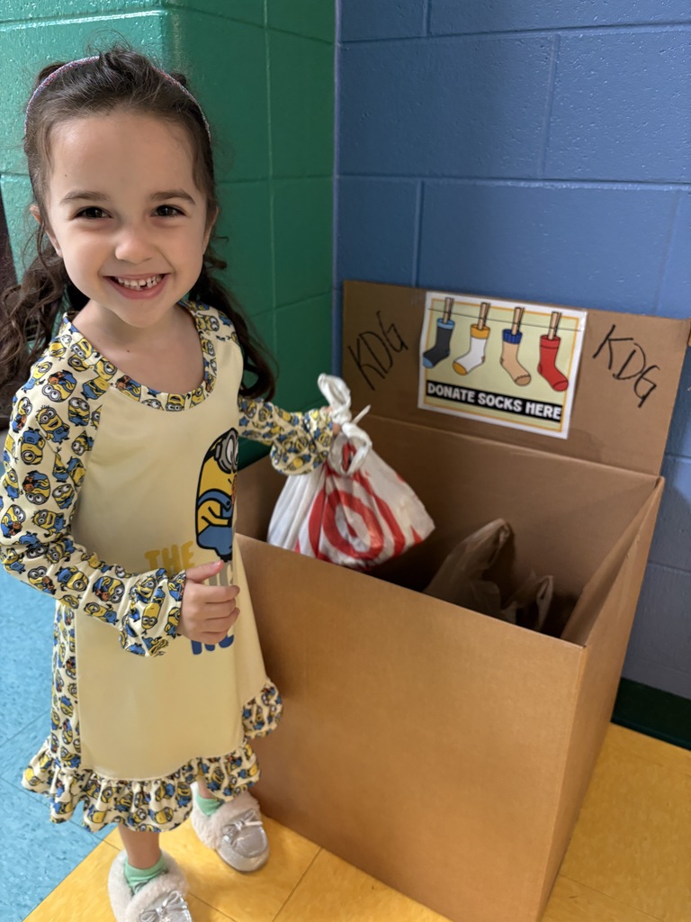 A girl with brown hair dropping a bag into a donation box