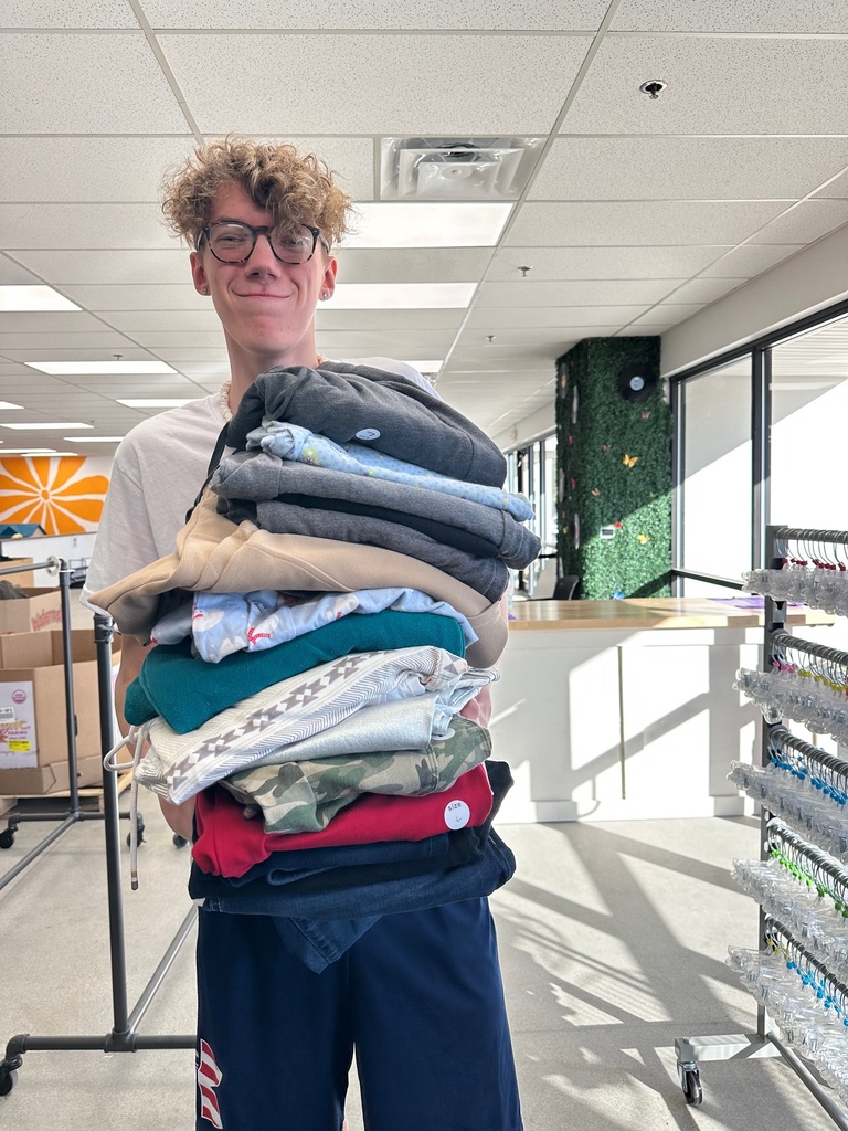 Blonde hiared boy holding folded clothes 
