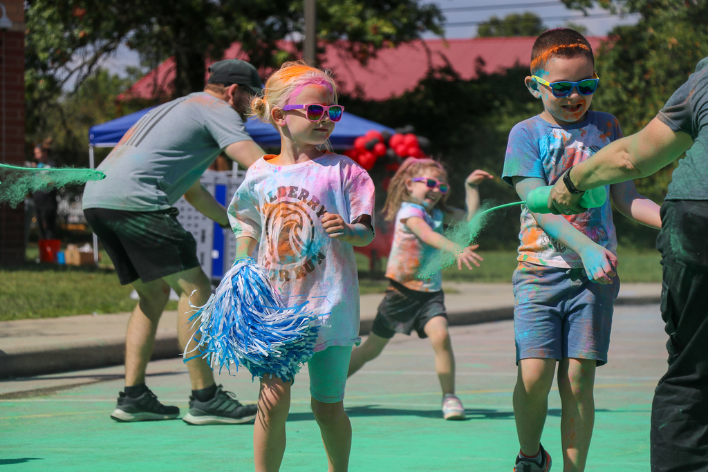 two kids getting sprayed with green dye