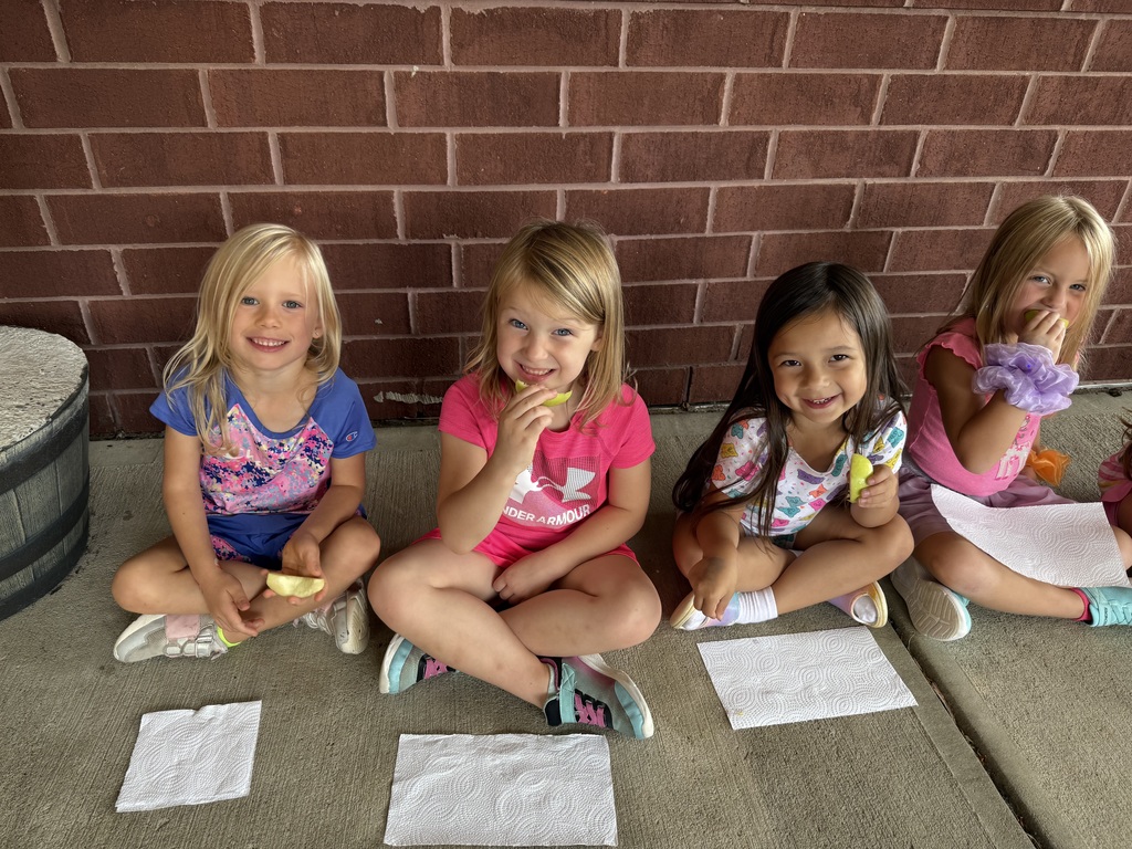 Three girls sitting down smiling at the camera