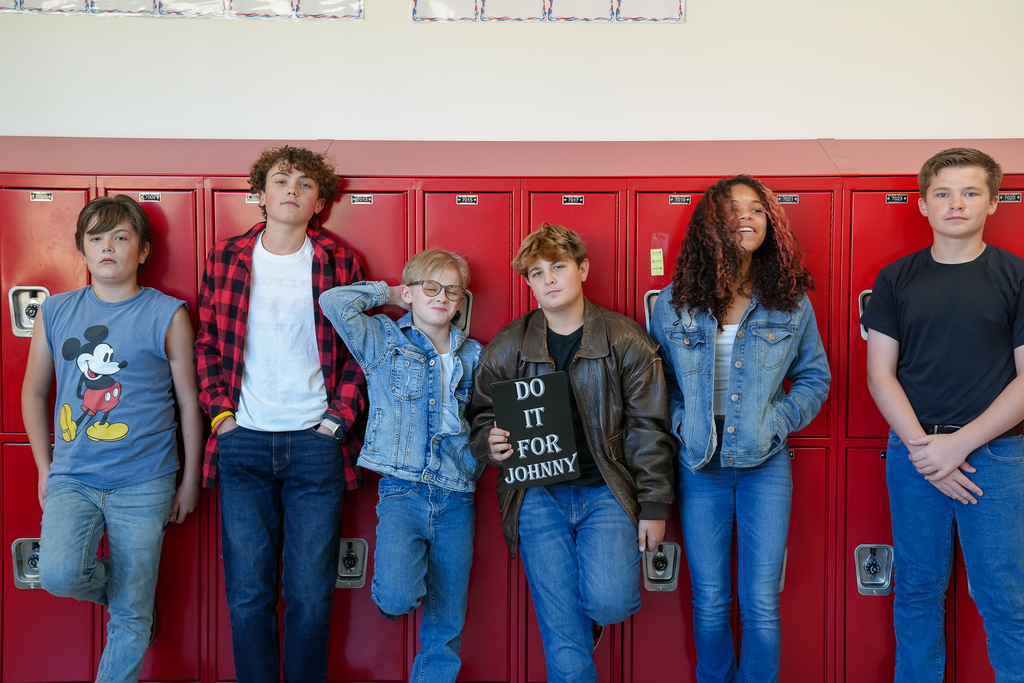 Group of kids looking cool against red lockers