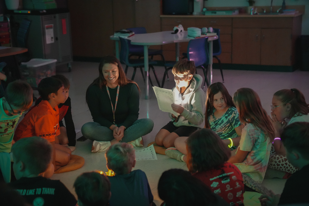 A group circle with a boy reading paper
