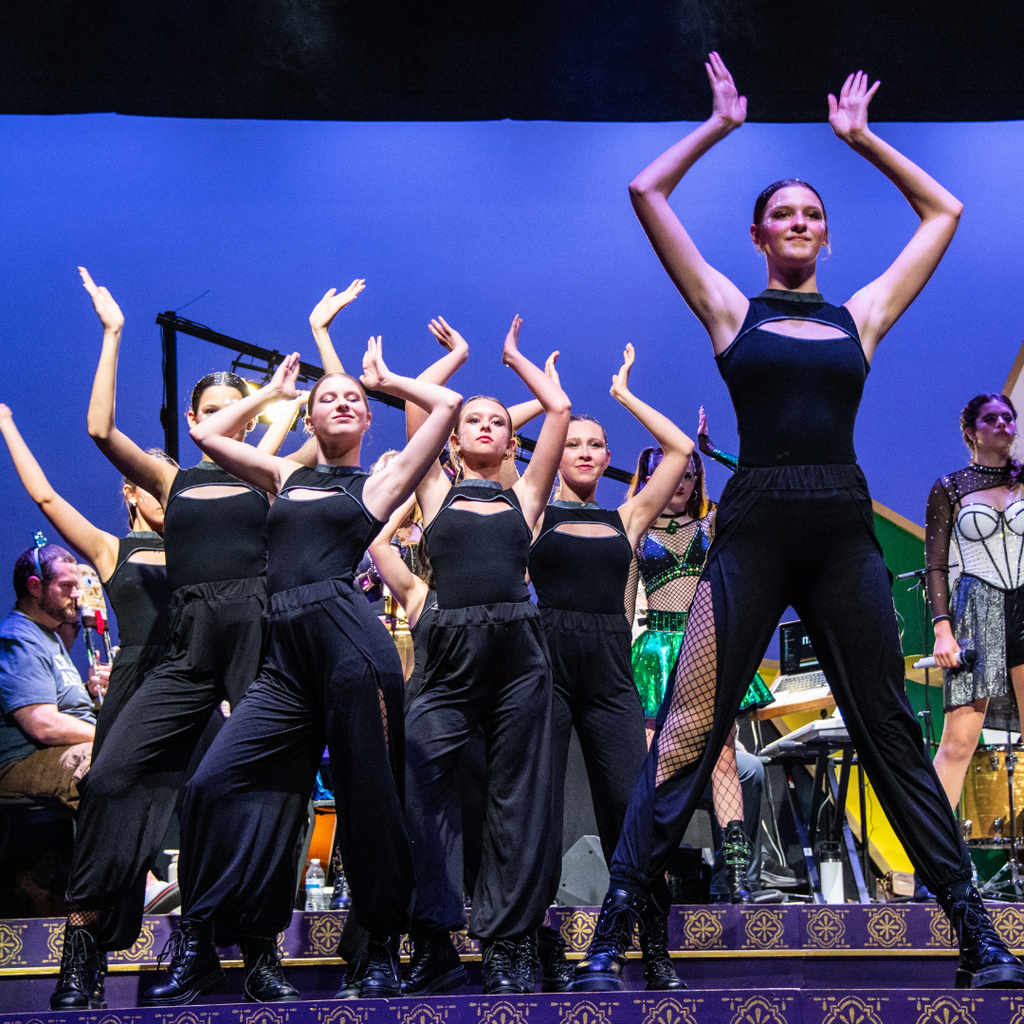 Women performers in black doing a choreographed dance