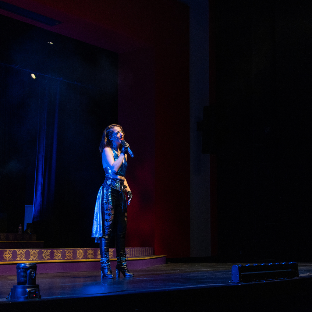 Woman in blue singing on stage