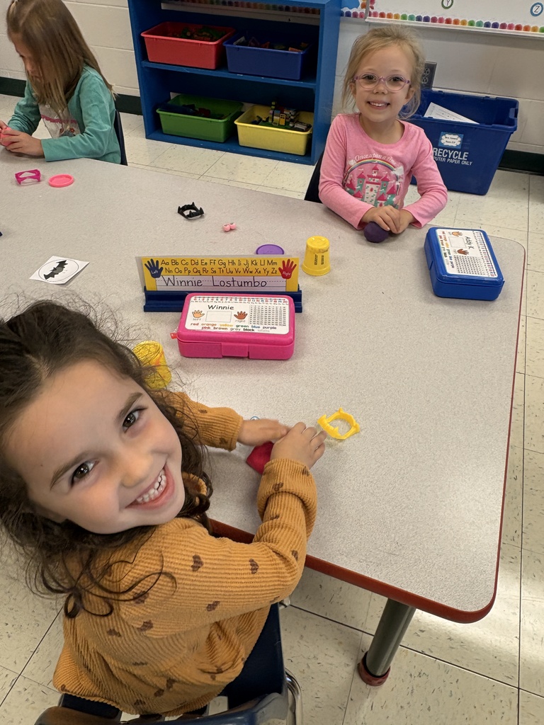 A girl smiling at the camera opposite of another girl smiling at the camera