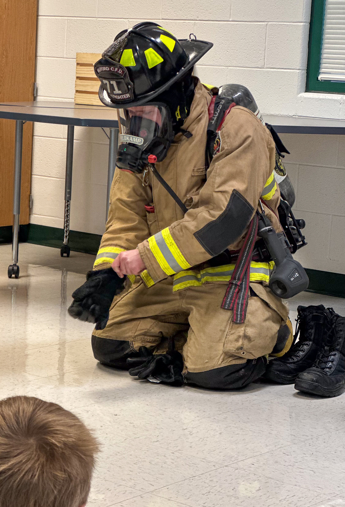 A firefighter putting on gloves