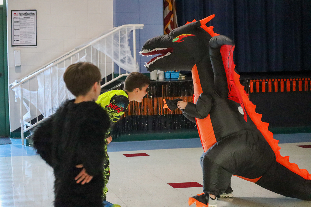 an inflatable dragon dancing with a student dressed up in yellow