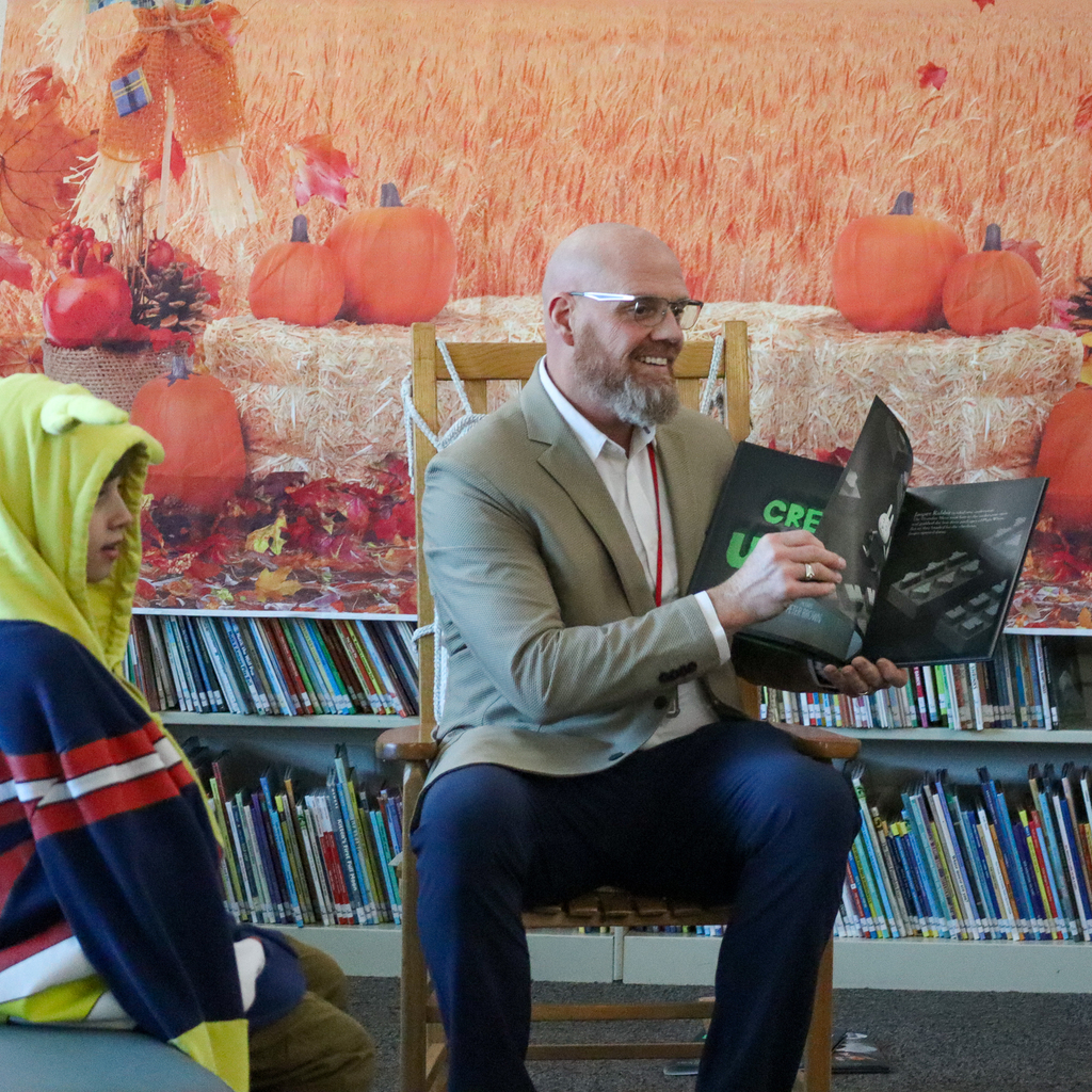 A man smiling reading a book