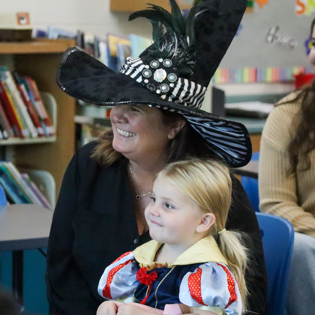 A woman dressed up as a witch holding a studnet dressed up as snow white