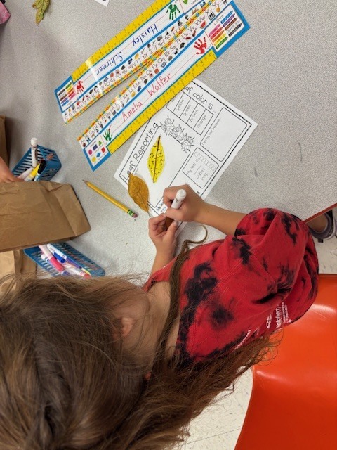 Girl with leaves on a paper