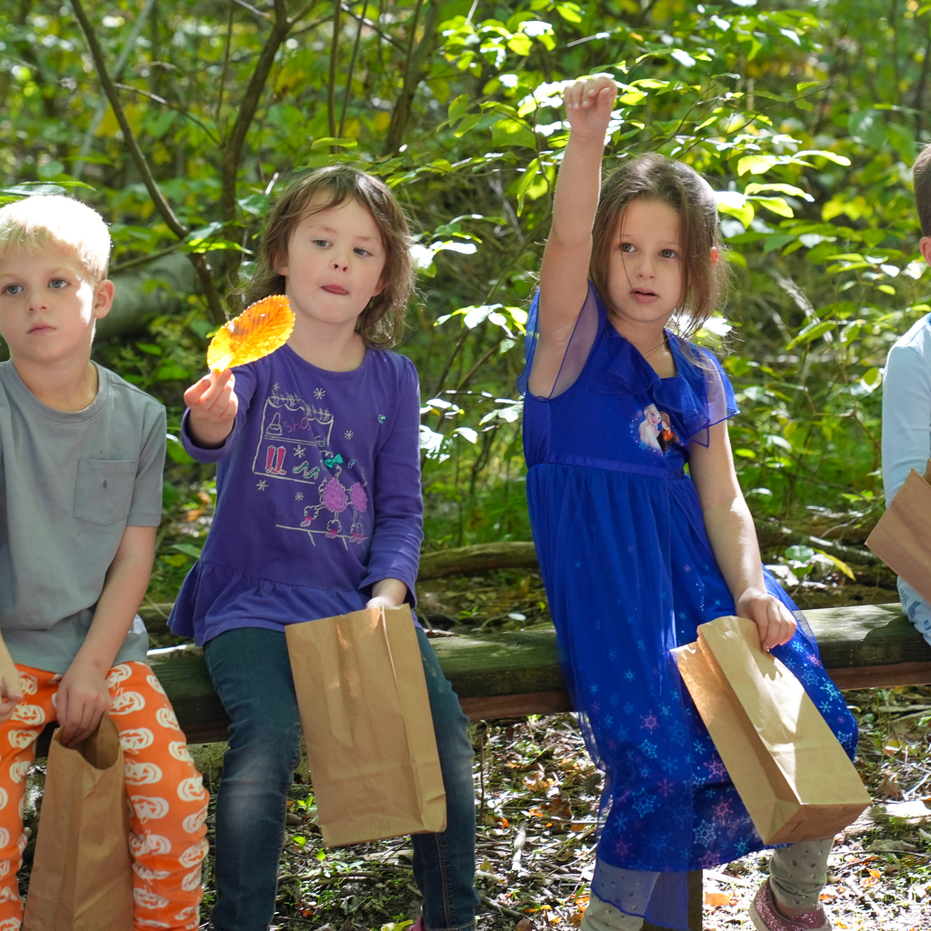 Two girls on a bench holding leaves