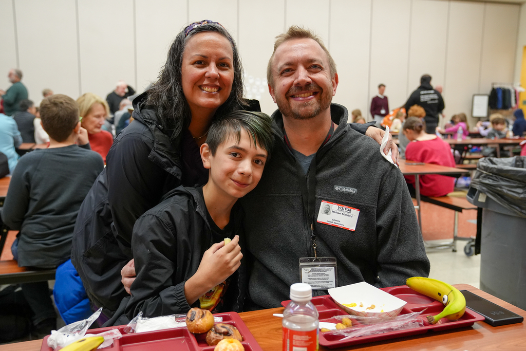 A student with two parents at breakfast