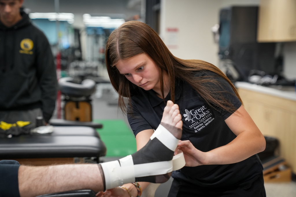 A student working on bandaging a foot