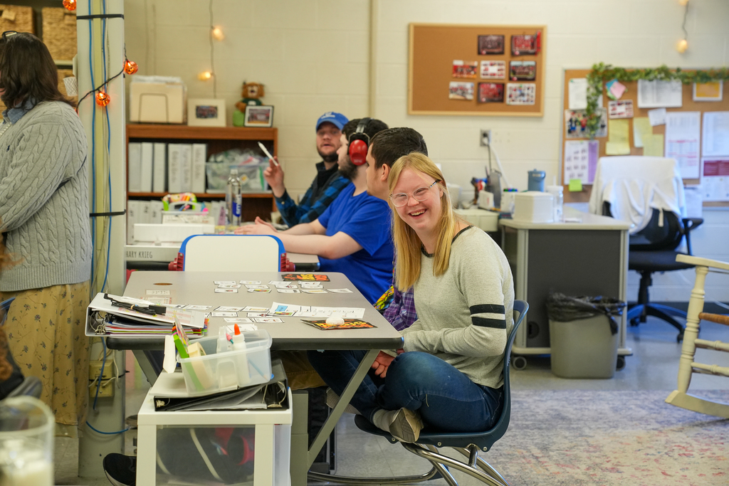 A student with glasses smiling at the camera