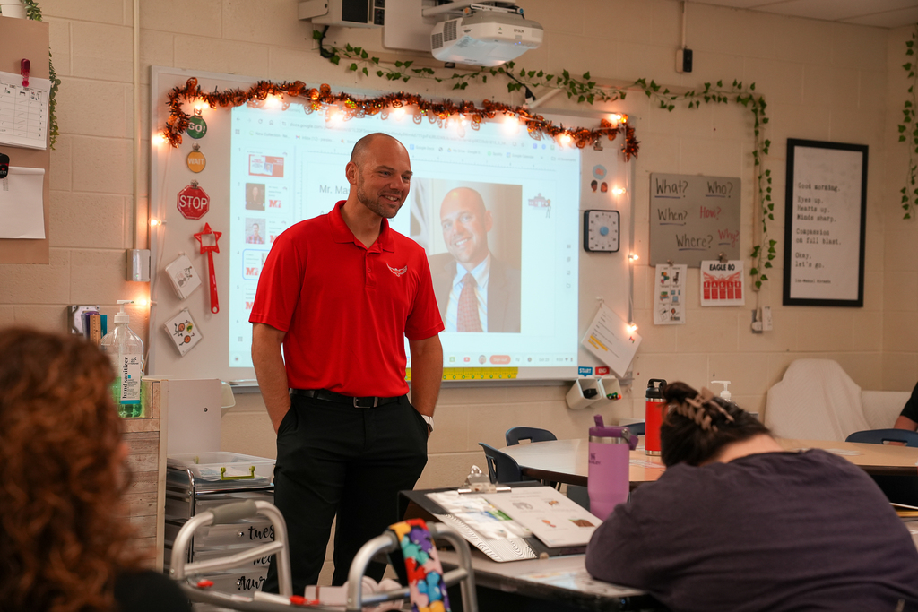 a bald man with a red polo shirt 