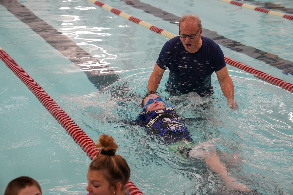 Man encouraging boy swiming