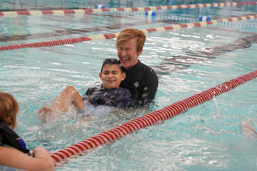 Boy splashing with woman smiling 