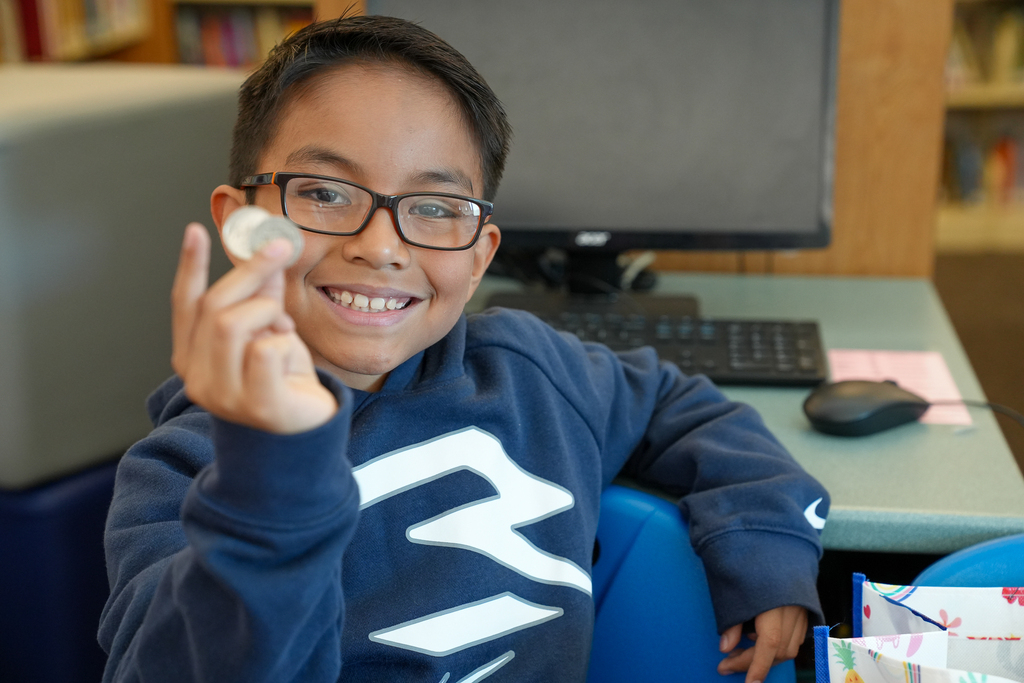 A student holding two quarters
