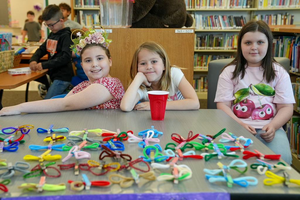Three students in front of fuzzy dragonflys