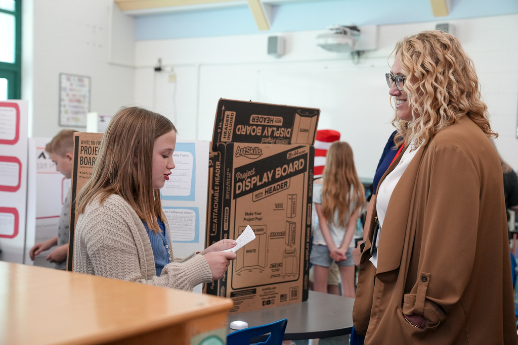 A student presents her historical figure project to a staff member during Meadowview Elementary’s Wax Museum event.