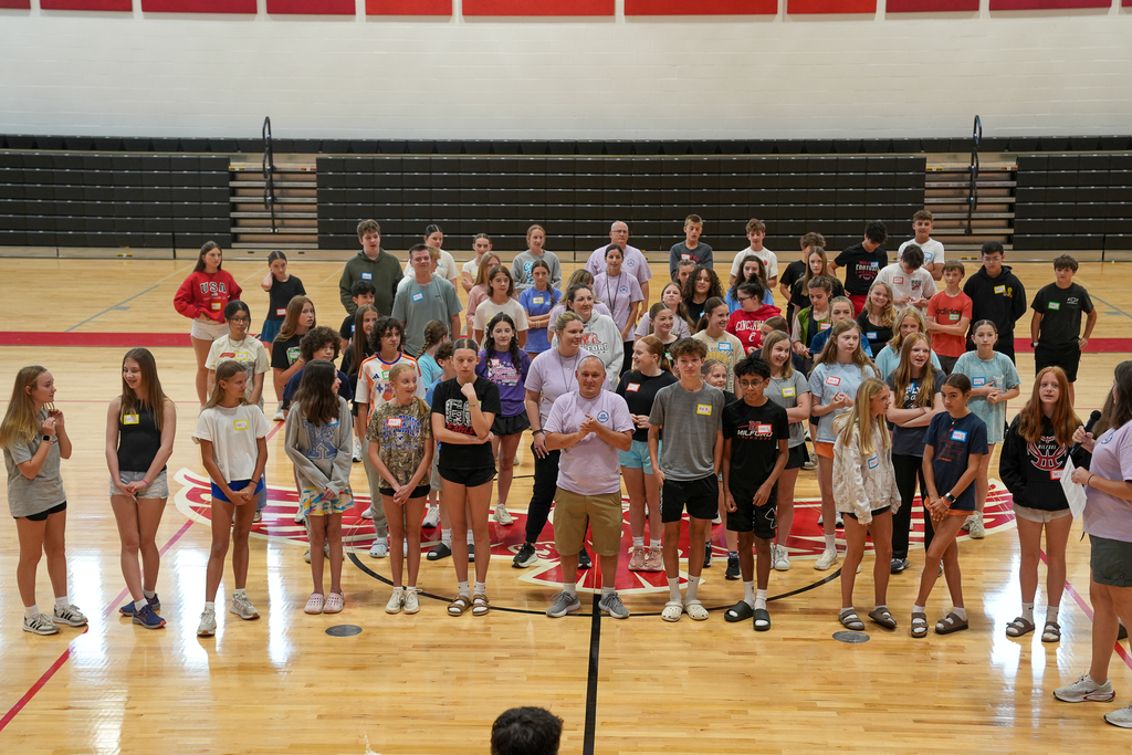 A large group of incoming WEB student leaders and staff members stand together on the Milford Middle School gym floor during team-building training activities.