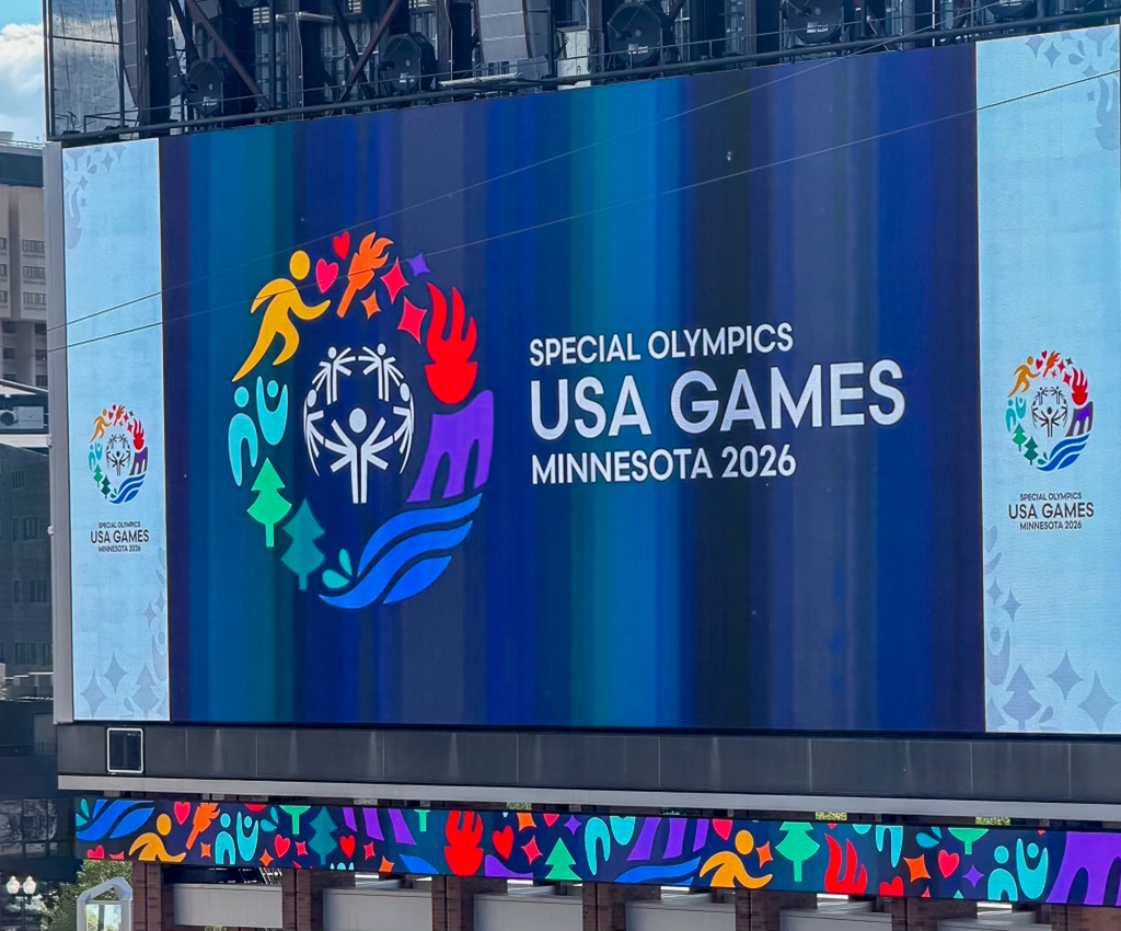 A large outdoor video screen displays the colorful Special Olympics logo and the words “Special Olympics USA Games Minnesota 2026.”