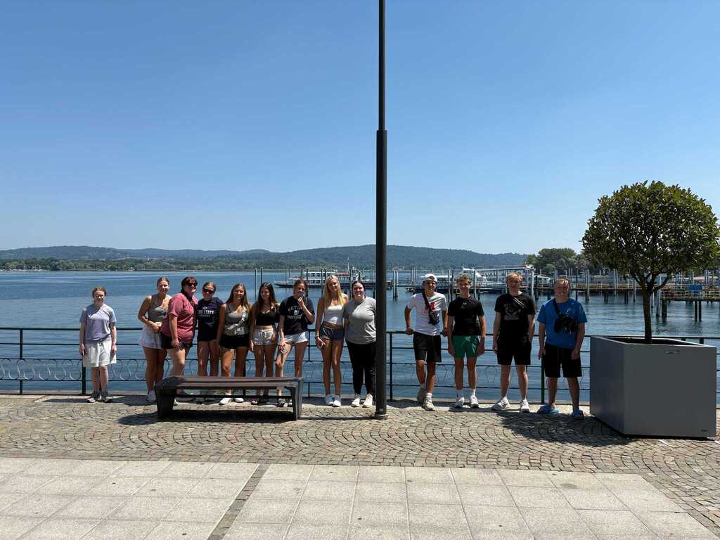 Group of Milford High School students posing together along a waterfront during their trip to Italy.