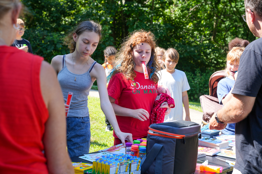 Students select colorful books and small prizes from an outdoor table during a Seipelt Elementary event.