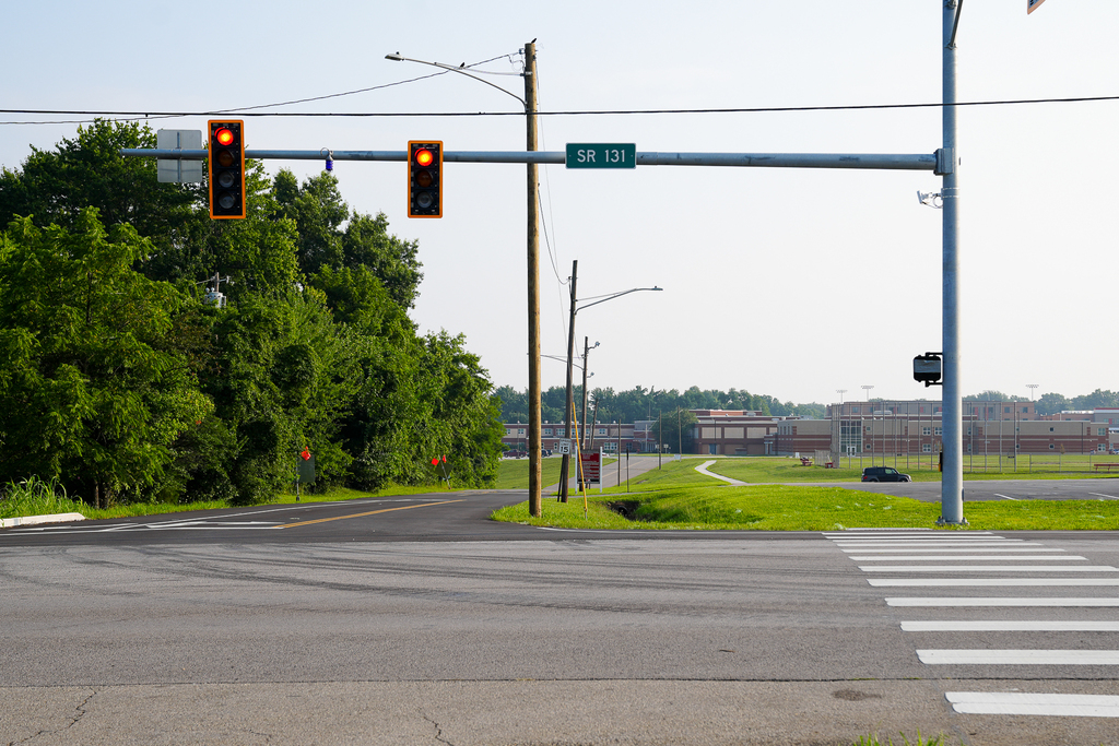 The new traffic signal and freshly painted crosswalk at State Route 131 and Eagles Watch Way, with Milford High School visible in the background.