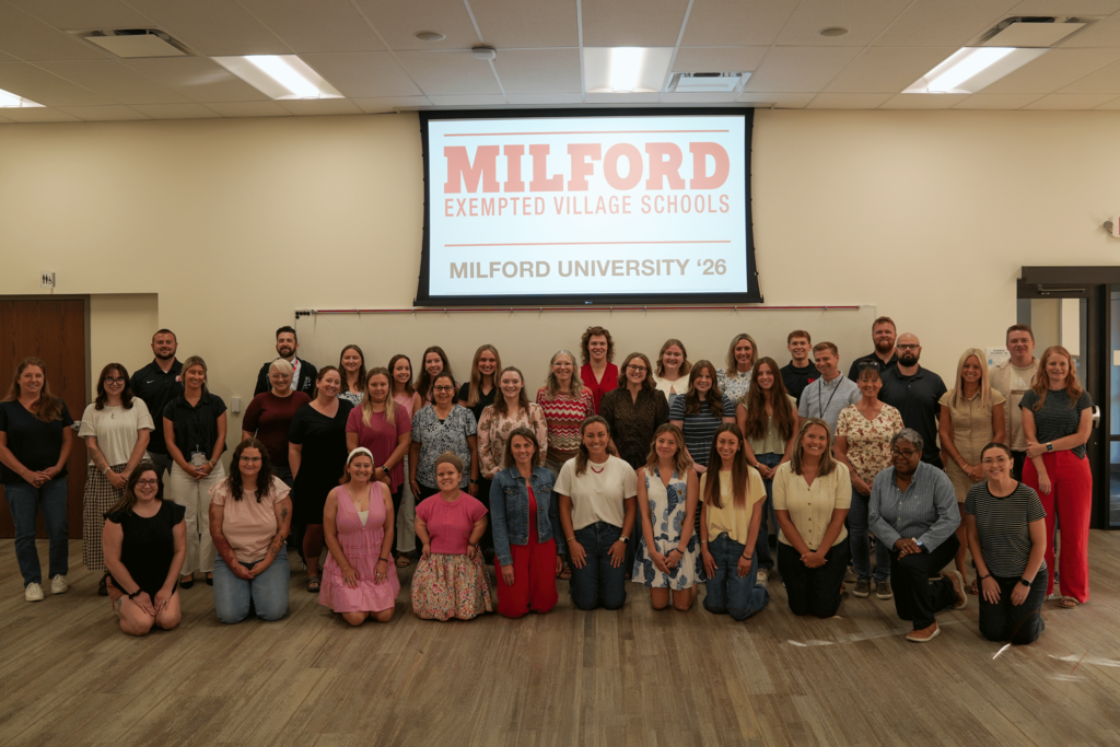 Milford University participants pose for a group photo beneath a screen displaying “Milford Exempted Village Schools: Milford University ’26.”