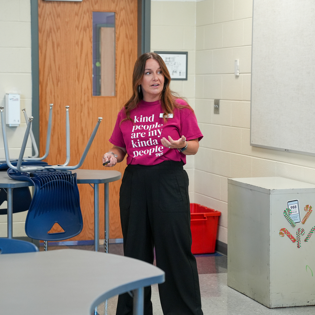 A Milford High School staff member leads a small group session during Freshman Orientation, speaking with incoming students in a classroom as they prepare for the school year.