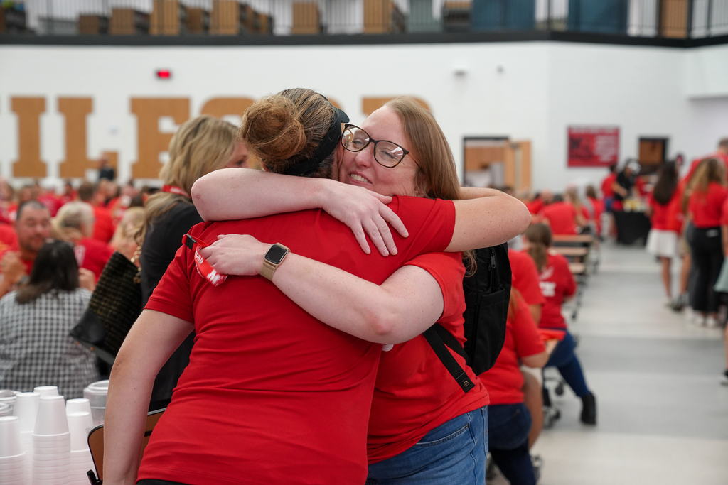 Two Milford staff members share a joyful hug during the annual staff convocation.
