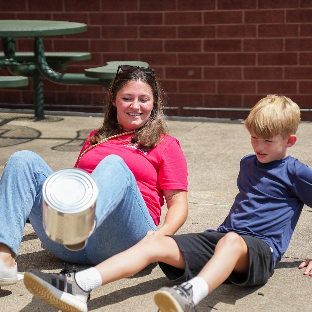 A McCormick Elementary staff member and student smile while participating in an outdoor team activity.