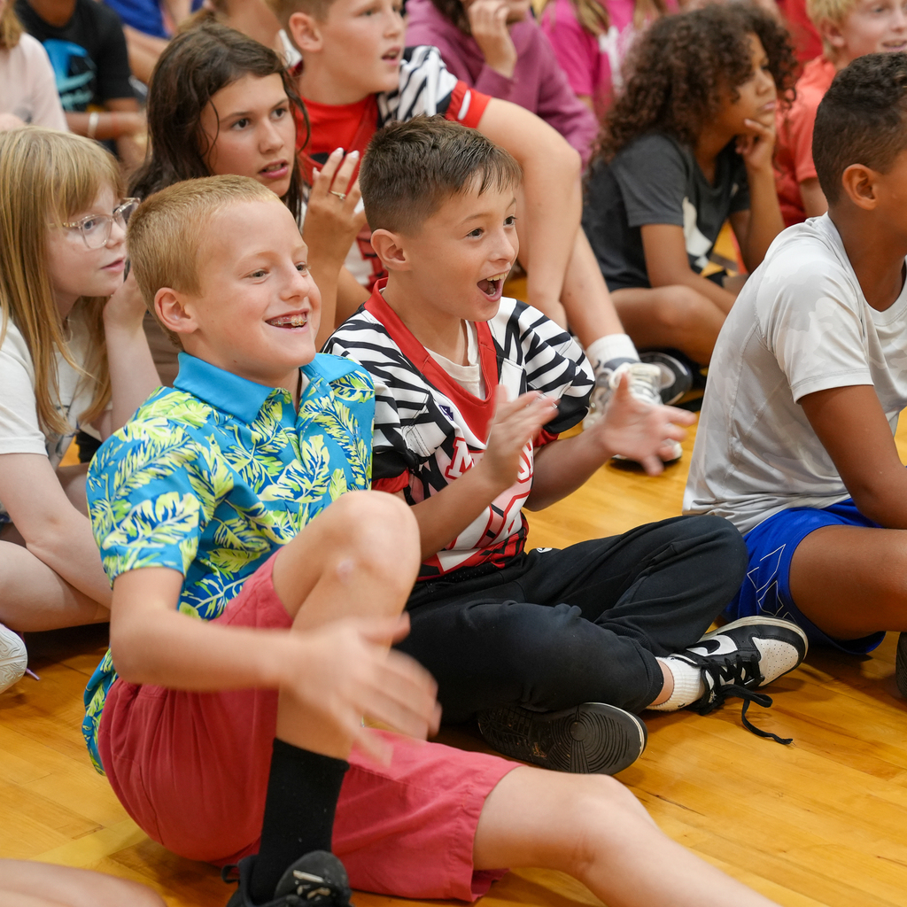 Boyd E. Smith students smile, clap and react excitedly while watching a school assembly.