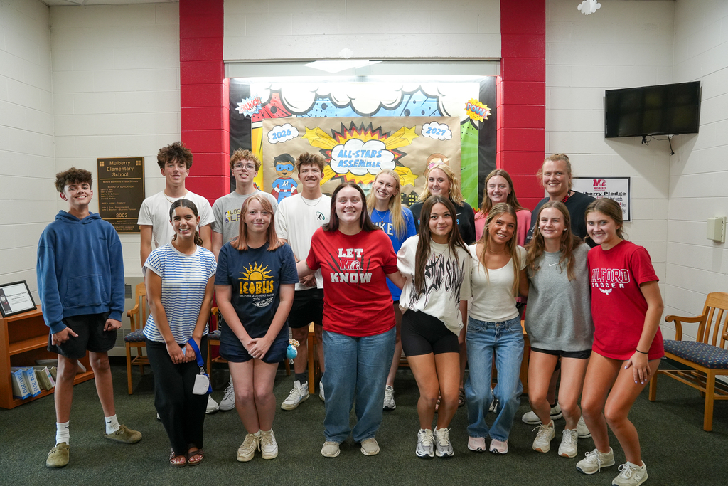 : Milford High School student mentors and Mulberry Elementary staff pose together for a group photo inside the school.