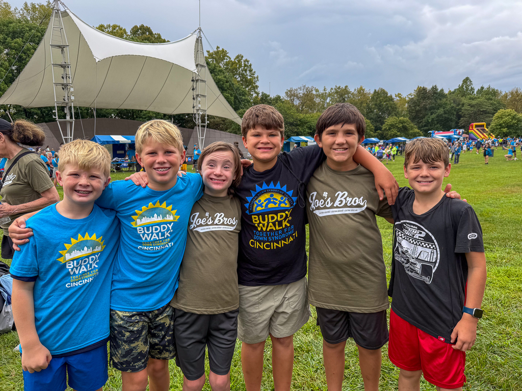 Six children stand with their arms around one another and smile during the Cincinnati Buddy Walk